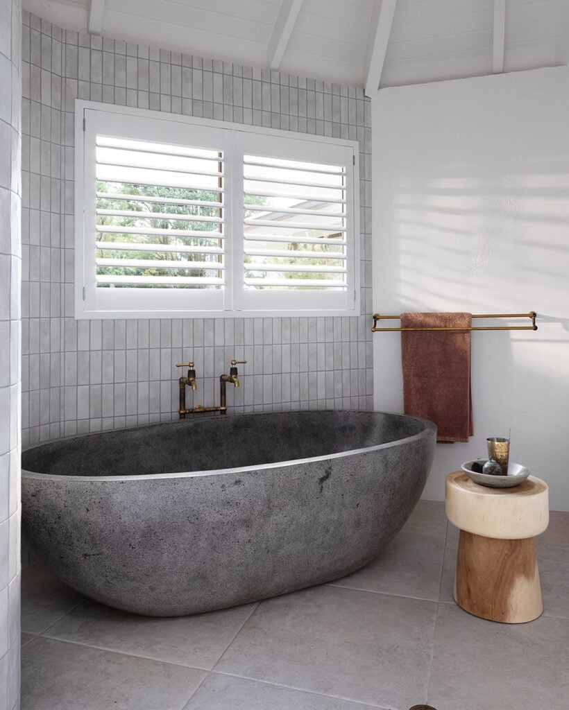 Stylish and practical, Norman’s Woodlore Plus Waterproof Shutters elevate this serene bathroom retreat, providing privacy and durability in a high-moisture environment.